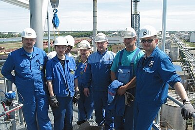 Gruppe von Ingenieuren in blauer Schutzkleidung auf Anlage